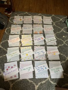 many pieces of paper that have been placed on top of a rug with writing all over them