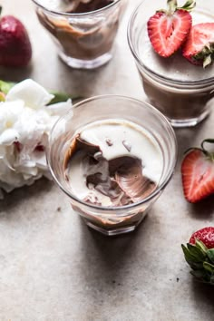 three glasses filled with chocolate pudding and strawberries