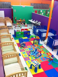 a room filled with lots of different types of furniture and toys on top of colorful mats