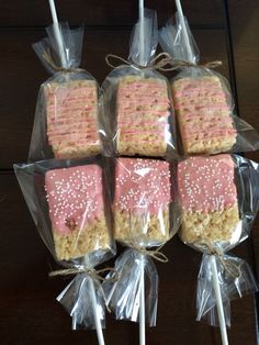 four pink and white cake pops wrapped in plastic