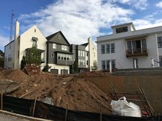 a large pile of dirt in front of some houses