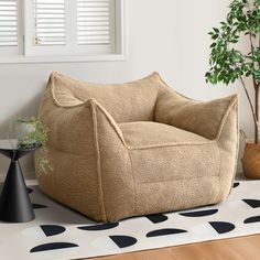 a bean bag chair sitting on top of a wooden floor next to a potted plant