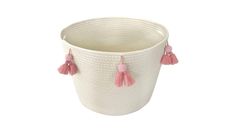 a white basket with pink tassels on the handles and bottom, sitting in front of a white background