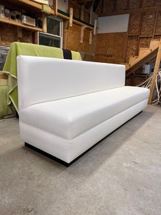 a white couch sitting on top of a cement floor