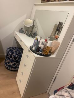 a white dresser topped with lots of bottles