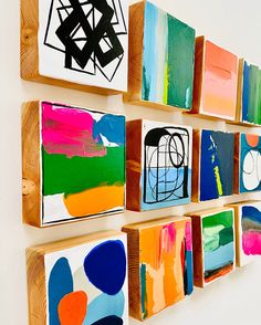 several colorful paintings are hung on the wall next to each other in different shapes and sizes