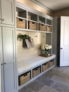 a room filled with lots of white flowers and baskets on top of the shelves next to each other