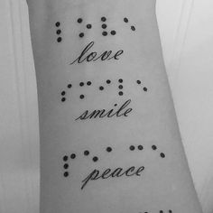 a person with a tattoo on their arm that says love, smile, and peace