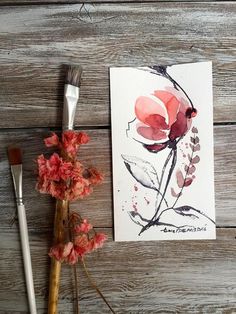 some flowers and paintbrush on a wooden table