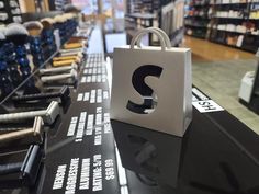 a shopping bag with the letter s on it sitting on a table in a store