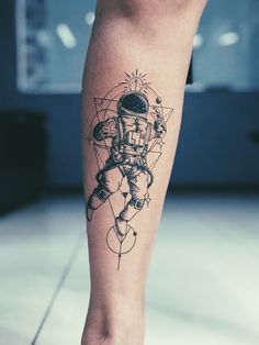 a tattoo on the leg of a person wearing an astronaut suit and space shuttles