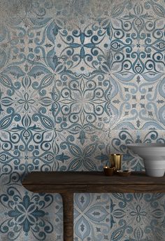 a blue and white wallpaper with an intricate design on the side table in front of it