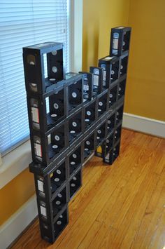 a bunch of wine bottles stacked on top of each other in front of a window