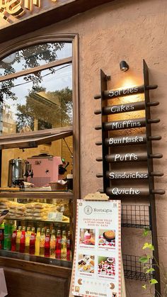 the outside of a bakery with signage and food items on display in front of it