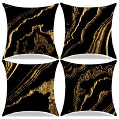 four black and gold decorative pillows on a white background