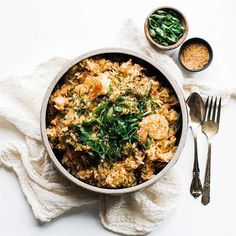 a bowl filled with rice and vegetables on top of a white table