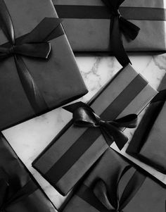 black and white photo of wrapped presents on marble counter top with ribbon tied around them