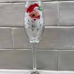 a wine glass with a santa clause painted on it