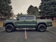 a green truck parked in a parking lot