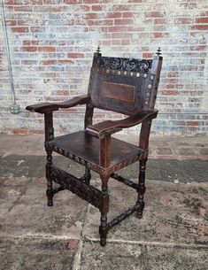 an old wooden chair sitting in front of a brick wall