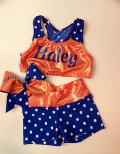 two piece swimsuit with name and polka dot print on it, one in blue and the other in orange