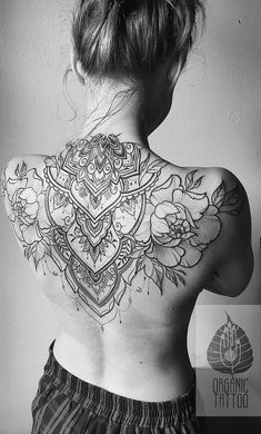 the back of a woman's body with tattoos on her upper and lower back