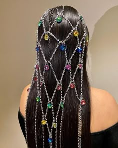 the back of a woman's head with chains and multicolored beads on it