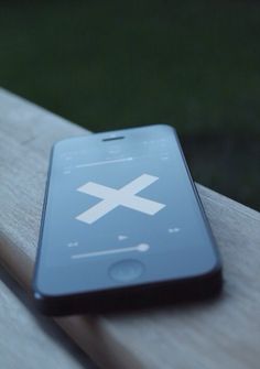 a cell phone sitting on top of a wooden bench