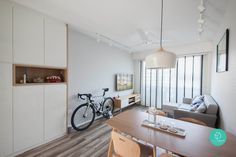 a living room filled with furniture and a bike mounted to the wall