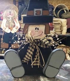 a scarecrow sitting on top of a table next to stacks of hats and other items