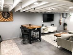 a living room filled with furniture and a flat screen tv mounted to the wall next to a bar