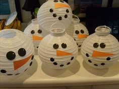 some paper lanterns with faces on them sitting on a table