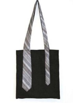 a black tote bag with a grey and white striped tie hanging from it's side