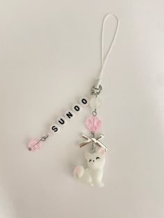 a keychain with a small white teddy bear hanging from it's side