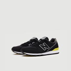 the new balance 997 in black with yellow and white trim on the upper part