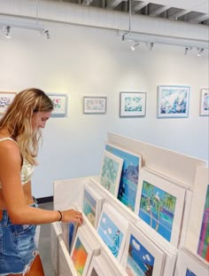 a woman is looking at pictures on display