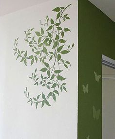 a bathroom with green and white paint on the walls, butterfly stencils on the wall