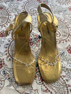 A pair of never worn gold vintage heeled sandals, women's size 9. M All sales are final. Gold Sandals With 4-inch Heel And Closed Toe, Gold Closed Toe Heels With Metal Feet, Gold Heels With Ankle Strap And 4-inch Heel, Gold Heels For Evening Summer Events, Gold Heels For Summer Evening, Gold Round Toe Heels For Night Out, Gold Sandals With Heel Strap For Night Out, Gold Heel Strap Sandals For Night Out, Gold Closed Toe Sandals For Party