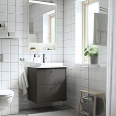 a bathroom with a sink, mirror and toilet in it's stall area next to a window