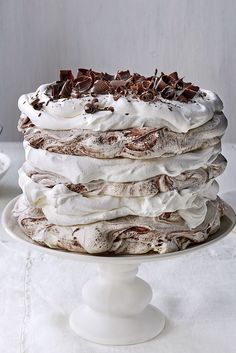 a cake with white frosting and chocolate shavings on top is sitting on a plate