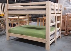 a bunk bed with green mattress in a room full of wood chairs and other furniture