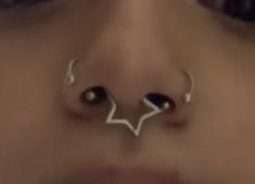 a woman's nose has two piercings on it