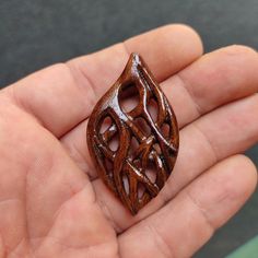 a hand holding a small wooden object in it's palm