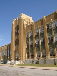 an old brick building with many windows and balconies on the top floor, in front of a clear blue sky