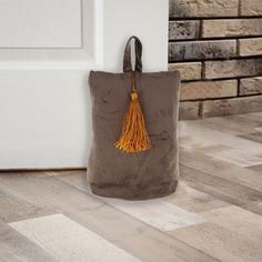 a brown bag with a tassel hanging from it's side on the floor