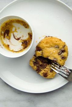 a white plate topped with two chocolate chip cookies and a cup of coffee