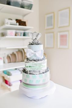 a multi tiered cake sitting on top of a white table next to a shelf