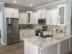 a kitchen with stainless steel appliances and white cabinets