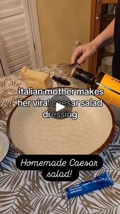 a woman pouring wine into a bowl on top of a table with cheese and bread