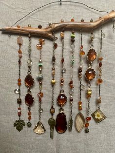 a wooden branch with many different beads hanging from it